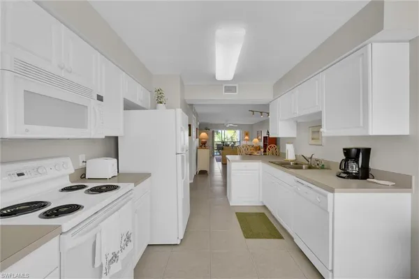 a kitchen with a sink a stove and cabinets