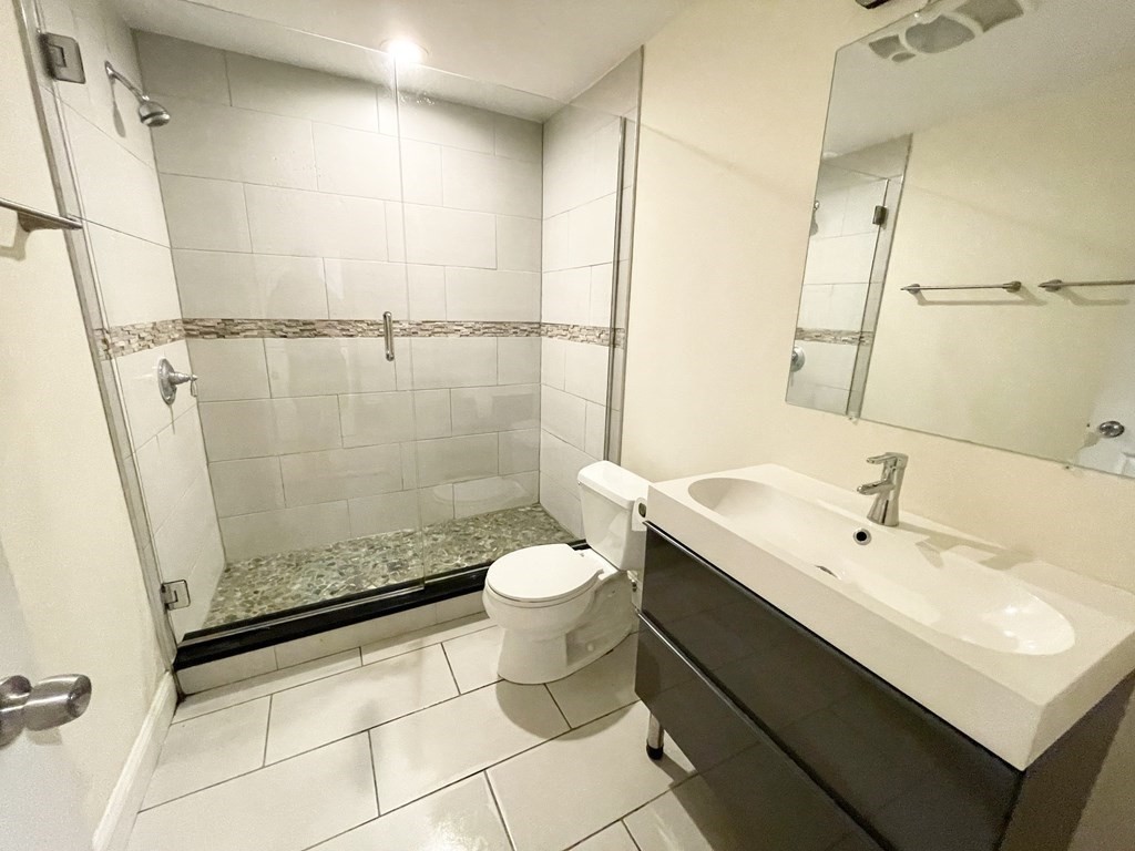 98 L Street, Unit STREET Boston, MA 02127 - Photo 17 of 19 a bathroom with a sink a toilet and shower