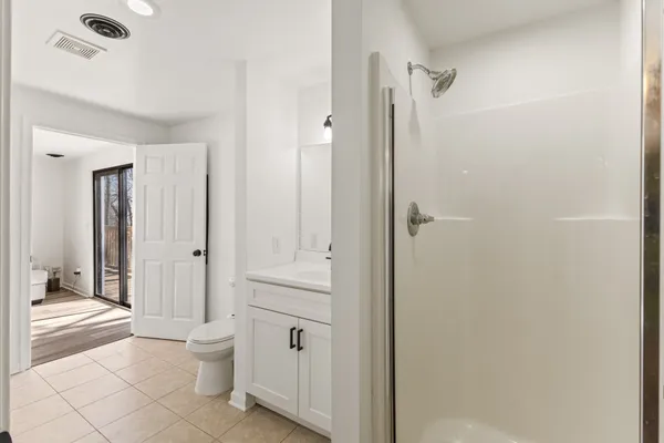 a bathroom with a granite countertop sink a toilet and shower