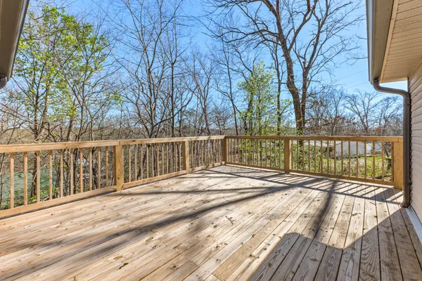 a view of a balcony with wooden floor and fence