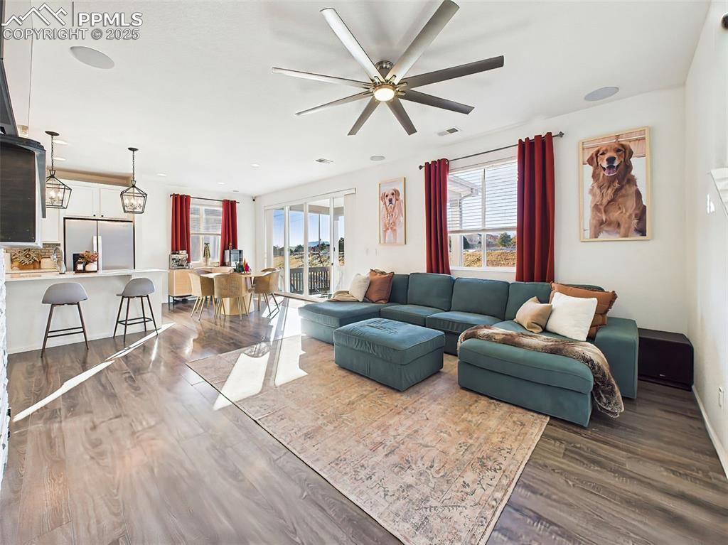 6272 Anders Ridge Lane Colorado Springs, CO 80927 - Photo 17 of 50 Expansive living space with oversized windows and easy access to the kitchen, dining, and patio areas—designed for both relaxation and connection.