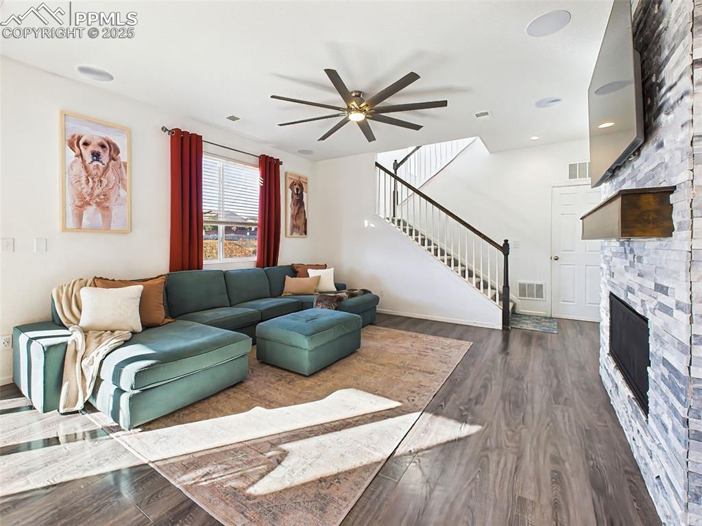 6272 Anders Ridge Lane Colorado Springs, CO 80927 - Photo 21 of 50 Another angle of the spacious great room with wide-plank flooring, ceiling fan, and upgraded stair railings leading to the second floor.