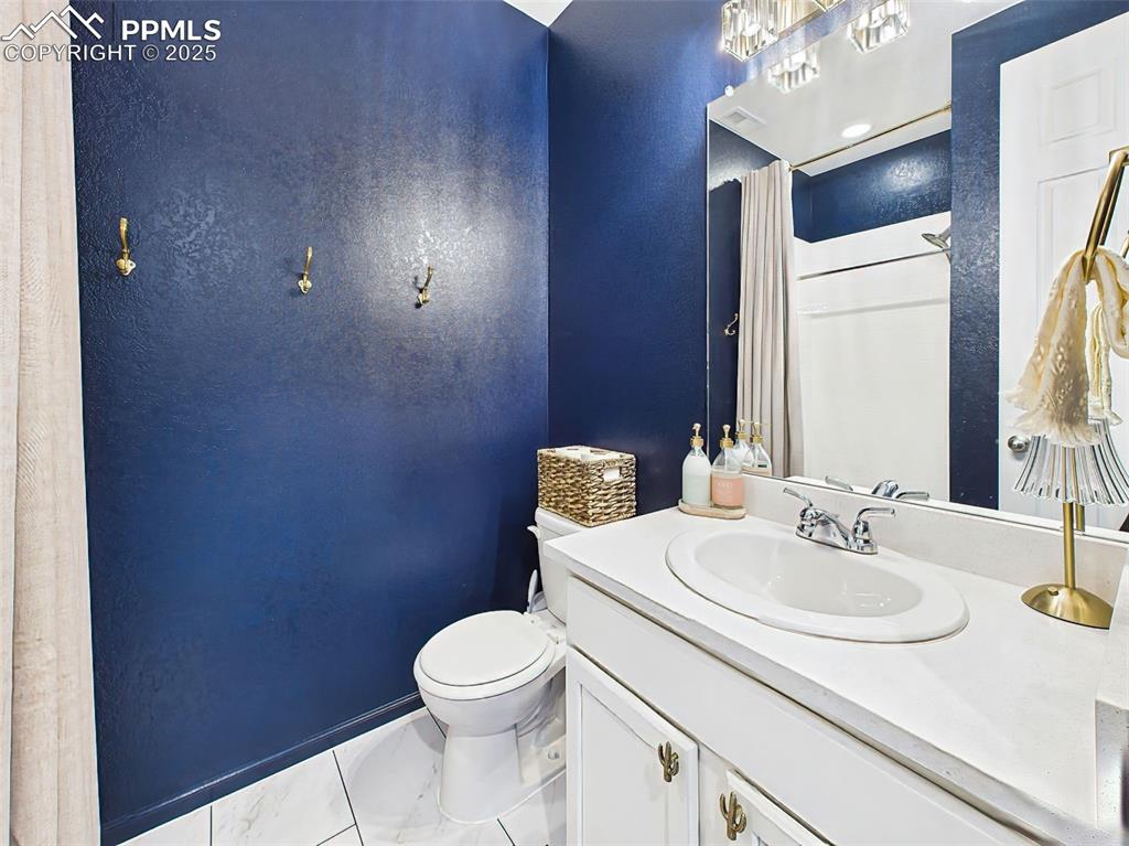 6272 Anders Ridge Lane Colorado Springs, CO 80927 - Photo 24 of 50 3/4 bathroom on the main level features chrome fixtures, white tile shower, and access to the hallway and nearby guest bedroom.