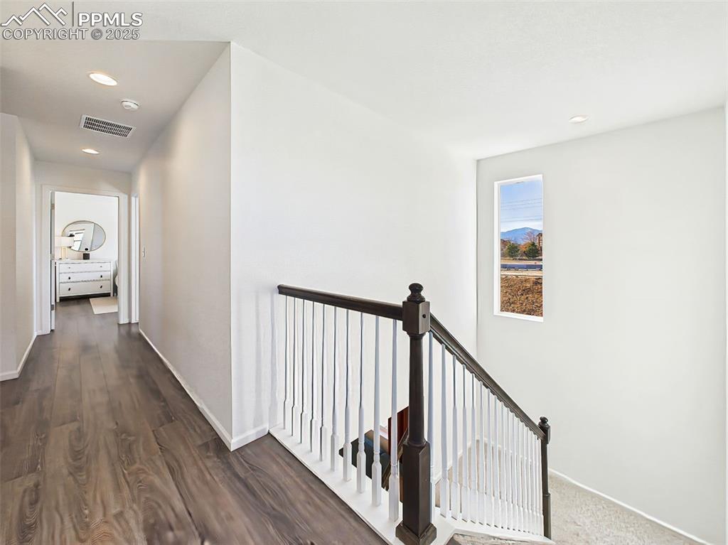 6272 Anders Ridge Lane Colorado Springs, CO 80927 - Photo 26 of 50 The upper landing offers a bright, open transition space with a picture window showcasing mountain views and durable wood-look flooring.