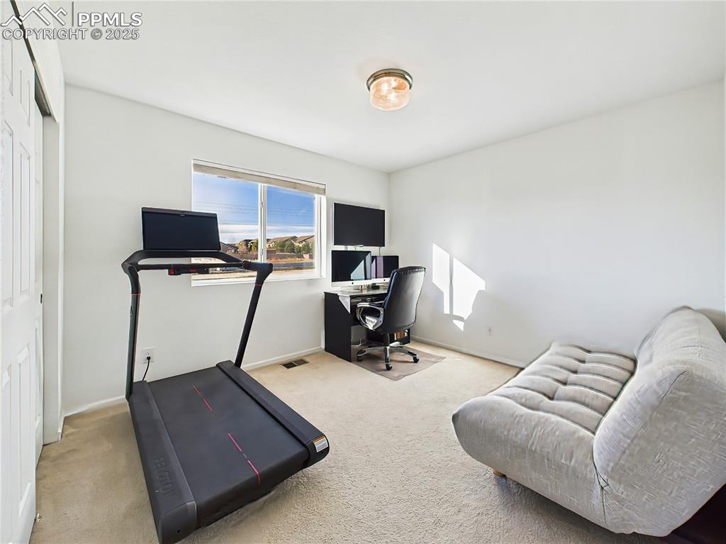6272 Anders Ridge Lane Colorado Springs, CO 80927 - Photo 35 of 50 Sun-filled secondary bedroom with a large window, ample closet space, and flexible use as a home office or guest room.