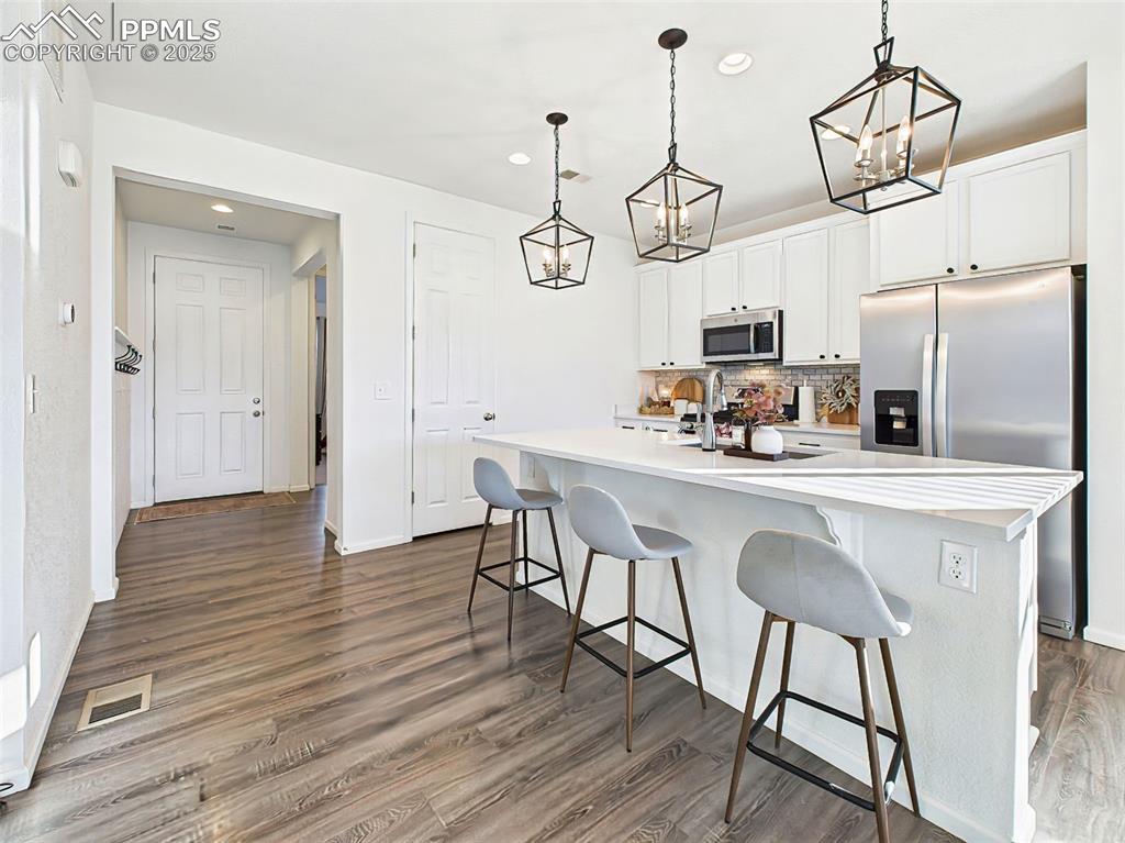 6272 Anders Ridge Lane Colorado Springs, CO 80927 - Photo 4 of 50 View from the kitchen toward the main entry shows luxury vinyl plank flooring and a neutral palette ready for any décor style.