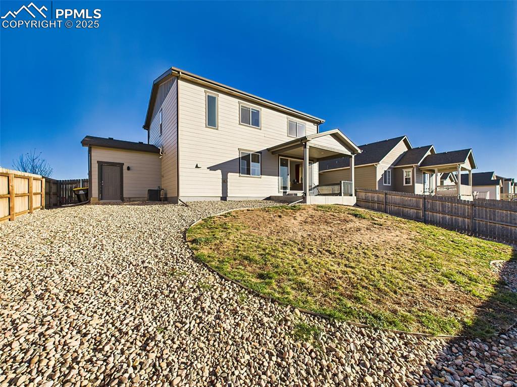 6272 Anders Ridge Lane Colorado Springs, CO 80927 - Photo 47 of 50 Back of the home features dual windows, a central slider, and walk-out access to the backyard from the dining area.
