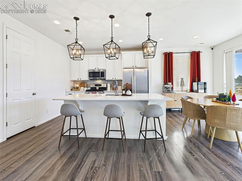 6272 Anders Ridge Lane Colorado Springs, CO 80927 - Photo 5 of 50 Light-filled dining nook sits just off the kitchen, surrounded by full-height windows and direct access to the covered back patio.