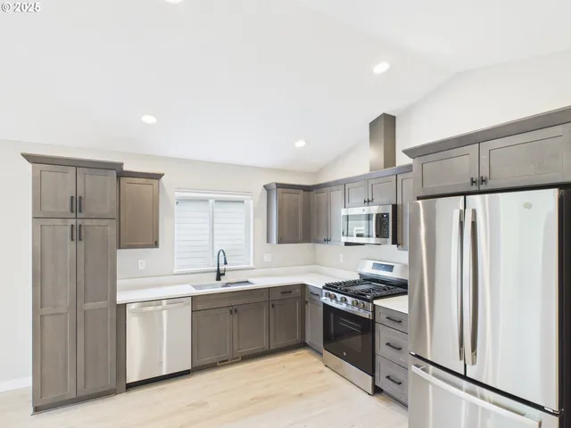 a kitchen with a sink stainless steel appliances and cabinets