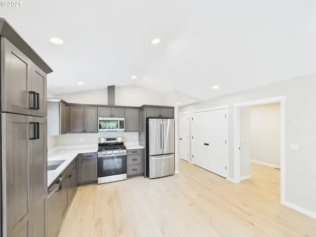 a kitchen with stainless steel appliances granite countertop a refrigerator and a sink