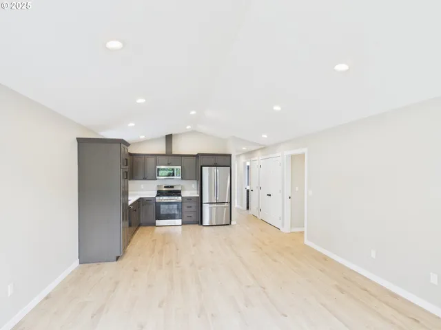 a view of kitchen with refrigerator cabinets and wooden floor