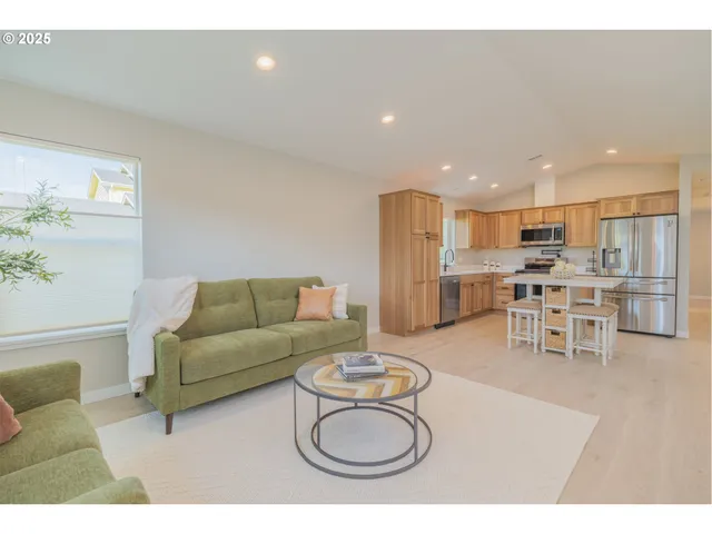 a living room with furniture a refrigerator and kitchen view