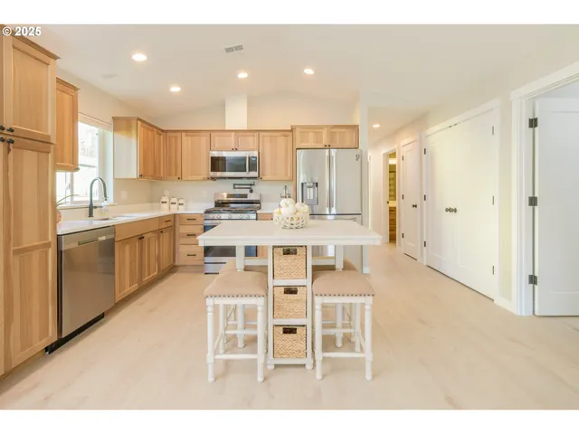 a kitchen with stainless steel appliances kitchen island granite countertop a sink and cabinets