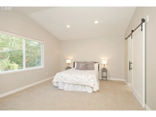 a bedroom with a bed and a large window