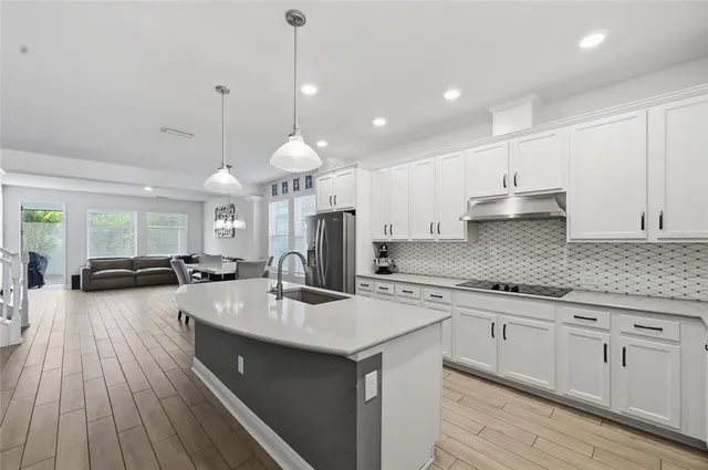a kitchen with a sink stove and wooden floor