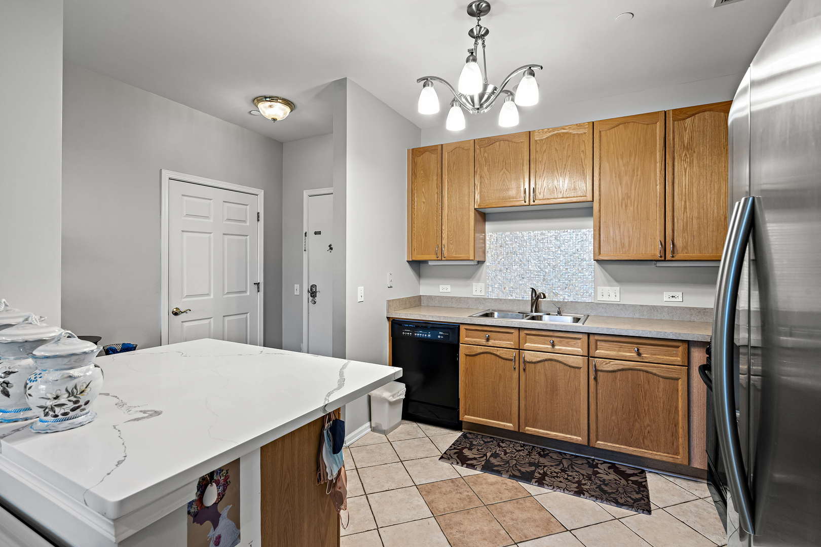 660 McHenry Road, Unit 306 Wheeling, IL 60090 - Photo 8 of 17 a kitchen with a sink dishwasher a stove a refrigerator and a dining table with wooden floor
