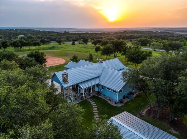 an aerial view of a house with pool and a patio