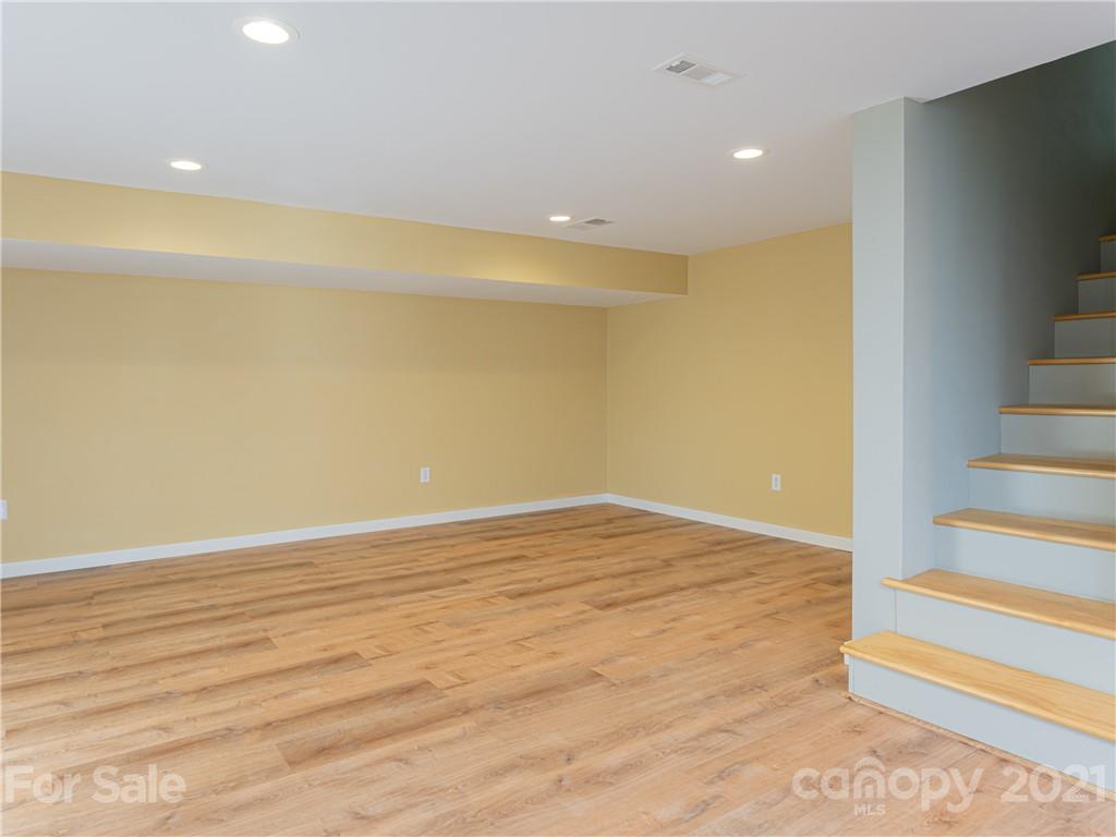 298 Erwin Hills Road Asheville, NC 28806 - Photo 24 of 48 a view of an empty room with wooden floor and a window