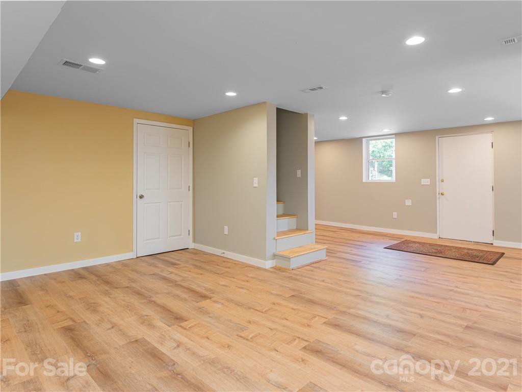 298 Erwin Hills Road Asheville, NC 28806 - Photo 25 of 48 a view of an empty room with wooden floor