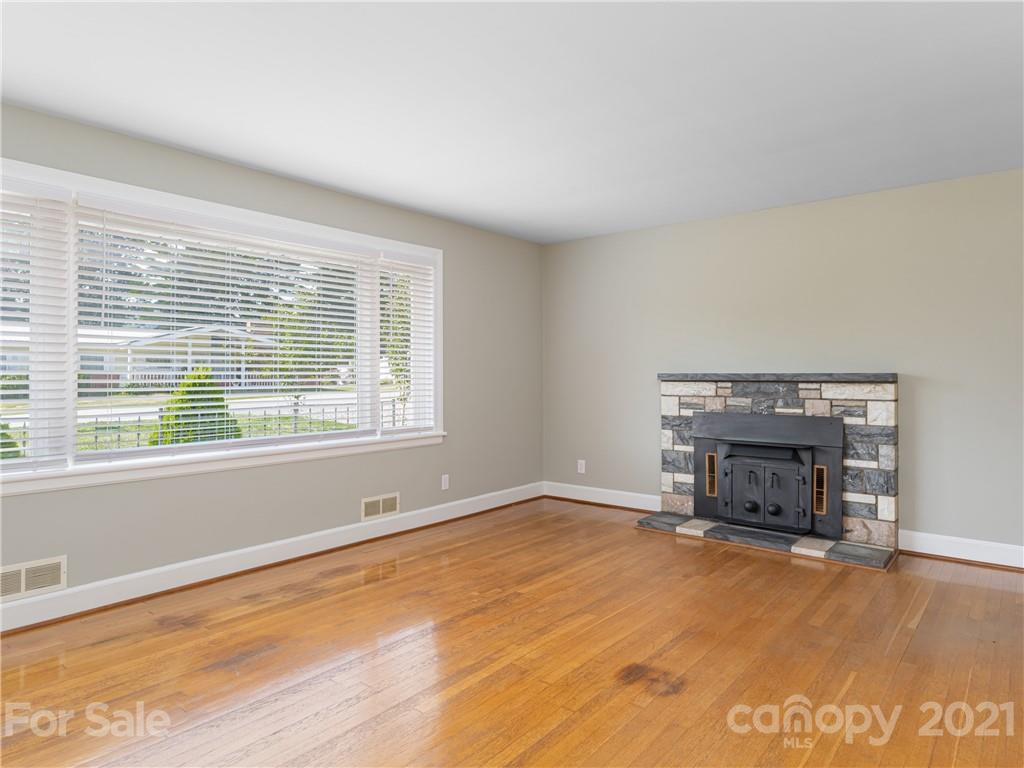 298 Erwin Hills Road Asheville, NC 28806 - Photo 4 of 48 a view of an empty room with a window and fireplace