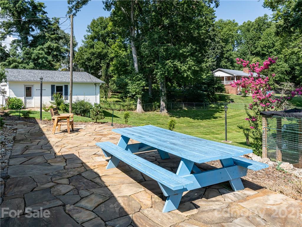 298 Erwin Hills Road Asheville, NC 28806 - Photo 32 of 48 a view of a patio with table and chairs potted plants and large tree