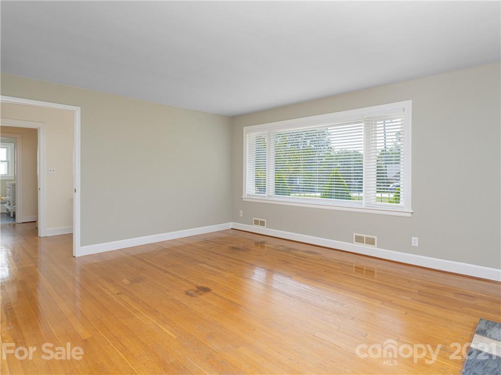 298 Erwin Hills Road Asheville, NC 28806 - Photo 6 of 48 a view of an empty room with wooden floor and a window