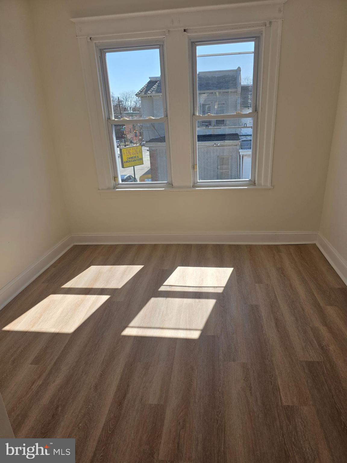5901 Belmar Street, Unit 3 Philadelphia, PA 19143 - Photo 6 of 10 an empty room with wooden floor and windows