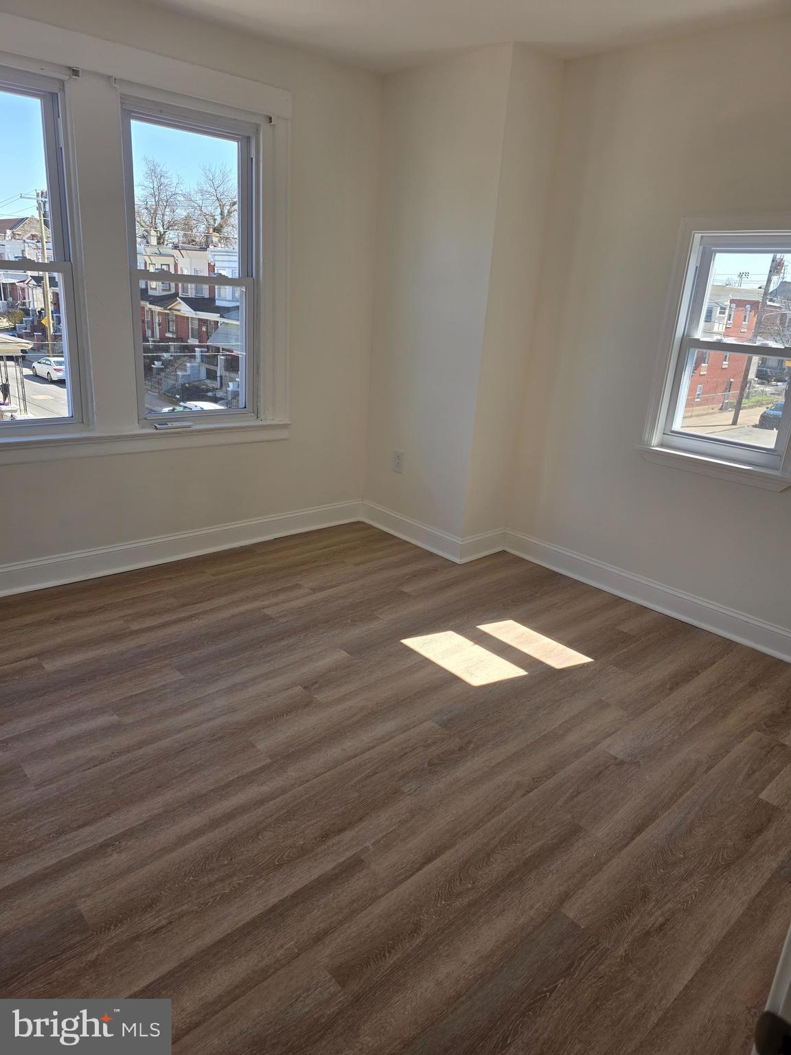 5901 Belmar Street, Unit 3 Philadelphia, PA 19143 - Photo 7 of 10 an empty room with wooden floor and windows