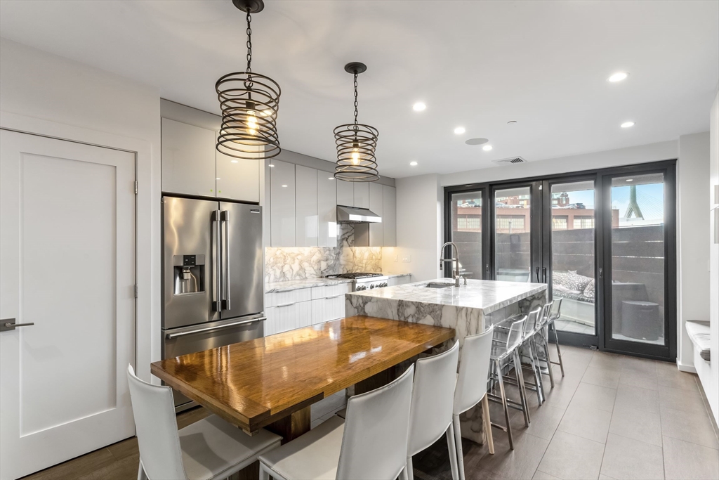 a kitchen with stainless steel appliances granite countertop a sink a refrigerator and a stove
