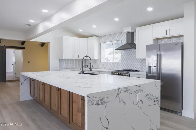 a kitchen with stainless steel appliances a sink stove and refrigerator