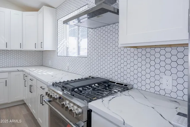 a stove top oven sitting inside of a kitchen