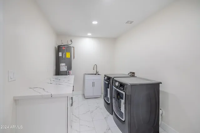 a utility room with cabinets washer and dryer