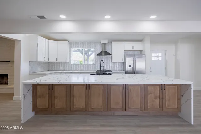 a large kitchen with granite countertop a sink and cabinets