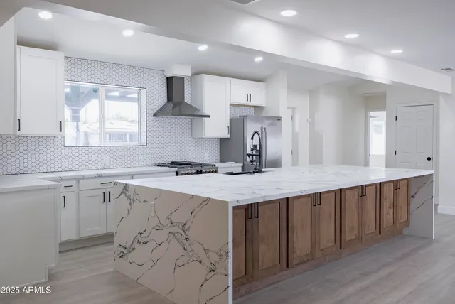 a kitchen with stainless steel appliances granite countertop a sink stove and refrigerator