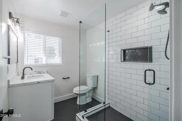 a bathroom with a sink toilet a mirror and shower