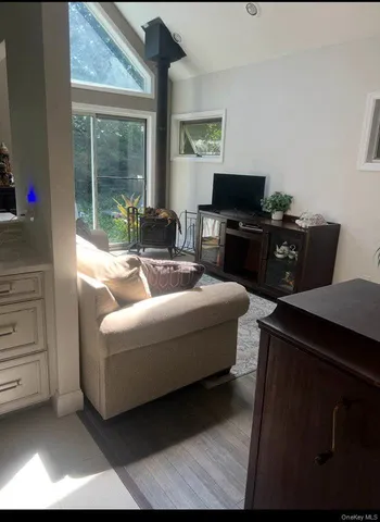 a living room with furniture a flat screen tv and a floor to ceiling window
