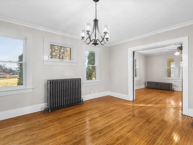 a view of a livingroom with wooden floor and a chandelier