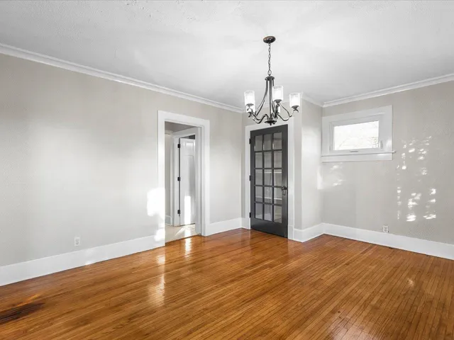 a view of empty room with wooden floor and window