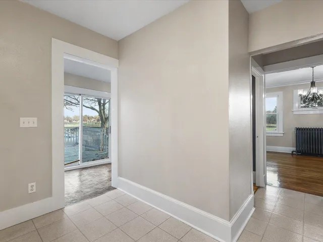 an empty room with wooden floor and a bathroom