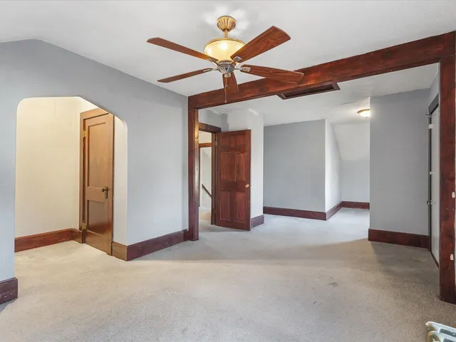 a view of a room with a ceiling fan and entryway