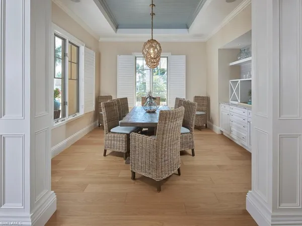 a dining room with furniture a chandelier and wooden floor