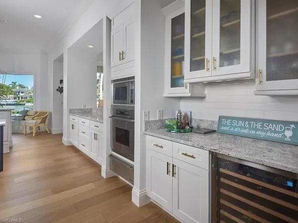 a kitchen with stainless steel appliances white cabinets and wooden floors