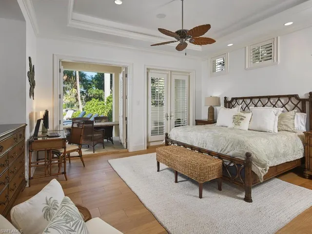 a spacious bedroom with a bed a couch and a chandelier