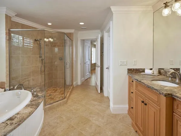 a bathroom with a granite countertop sink a mirror and a bathtub