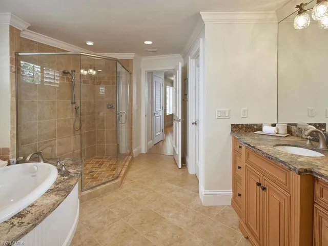 a bathroom with a granite countertop sink a mirror and a bathtub