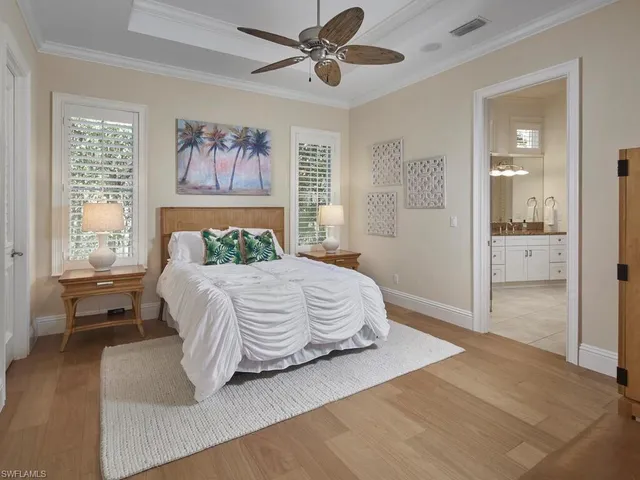 a bedroom with a large bed and a chandelier