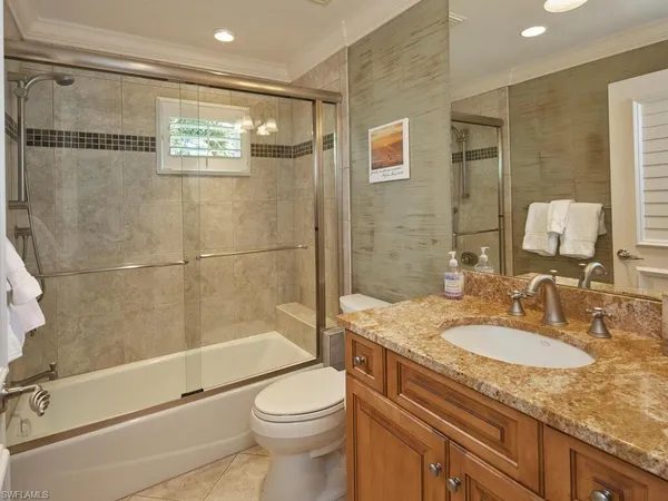a bathroom with a granite countertop sink a toilet and shower