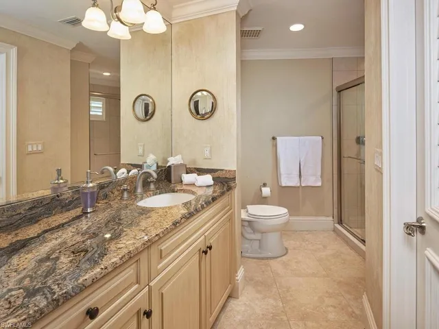 a bathroom with a granite countertop sink a toilet and a mirror