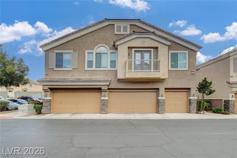 1571 Rusty Ridge Lane Henderson, NV 89002 - Photo 1 of 26 A contemporary multi-level facade features a private balcony and multiple garages, blending functionality with modern design.