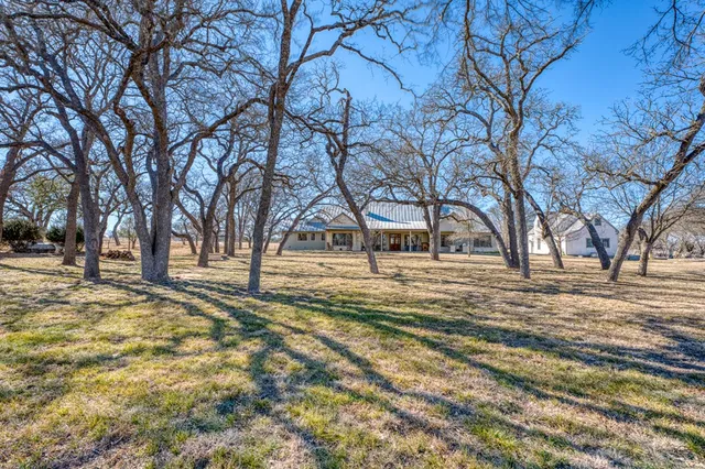 a view of a white house with a yard